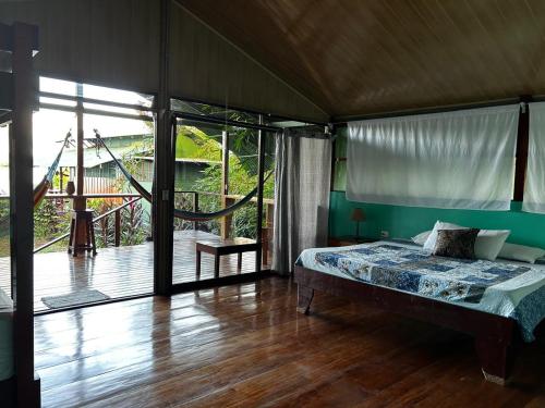 a bedroom with a bed and a sliding glass door at The Monkey Trail Hostel in Drake