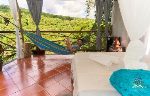 a man sleeping in a hammock in a room at Hostal Ariantiy in Pepino