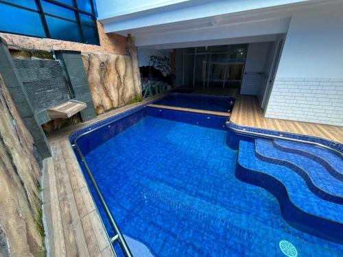 ein großer blauer Pool in einem Gebäude in der Unterkunft Villa Arundaya Kota Batu in Punten