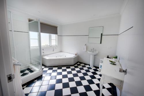 een badkamer met een zwart-wit geruite vloer bij Upper Reach Spa Cottage in Henley Brook