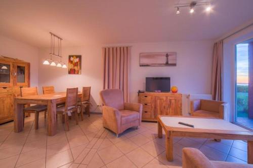 ein Wohnzimmer mit Tisch und Stühlen und einem Fernseher in der Unterkunft Gartendeck 431 in Rechlin