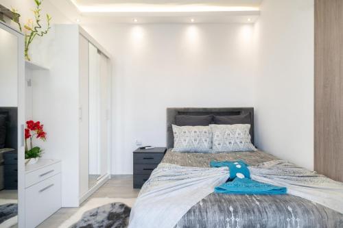 a bedroom with a large bed and a white wall at Zeffie's Studio in Olympiada