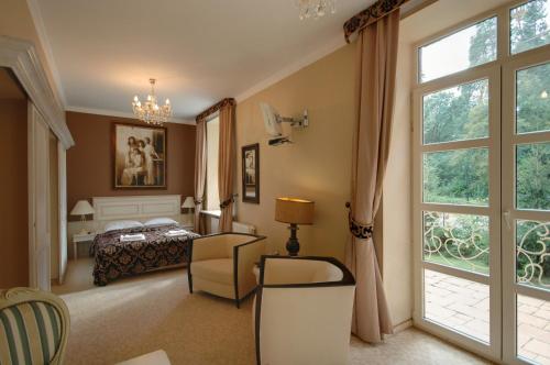 a bedroom with a bed and a large window at Dwór Carski in Spała