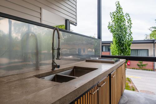 an outdoor kitchen with a sink and a window at Aberdeen Lane in Woodside