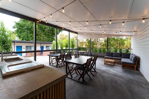 a patio with tables and chairs and a couch at Aberdeen Lane in Woodside