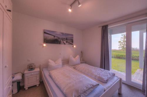 a bedroom with a large bed and a large window at Gartendeck 532 in Rechlin