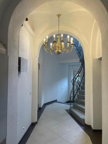 a hallway with a chandelier and a staircase at Ferienwohnung Zimmermann in Bad Schandau