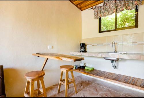 una cocina con 2 taburetes y un fregadero en Miniapartamento el Guanacaste, cerca Tamarindo, en Santa Cruz