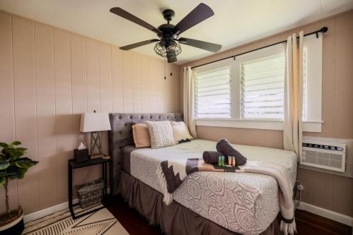 1 dormitorio con 1 cama y ventilador de techo en Hale Leilani - Hilo 3BR cold AC en Hilo