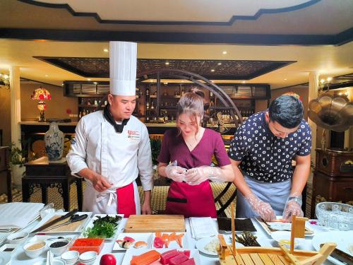 a group of people in a kitchen preparing food at Indochine Cruise Lan Ha Bay in Ha Long