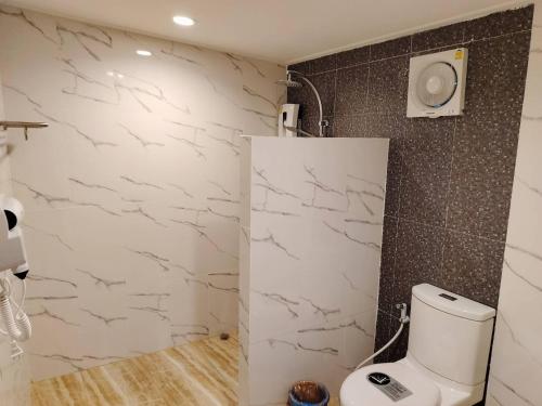 a bathroom with a toilet and a wall with marble at Greatland Glamping Khao Yai Resort in Ban Khanong Phra Tai