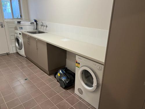 a kitchen with a sink and a washing machine at Guichen Villa 3 - Wi-Fi Pets welcome outside in Robe