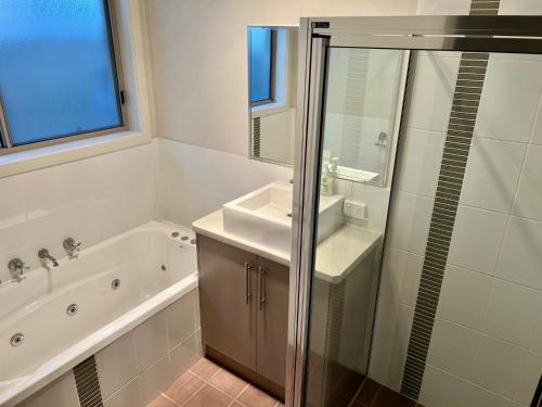 a bathroom with a tub and a sink and a shower at Guichen Villa 3 - Wi-Fi Pets welcome outside in Robe