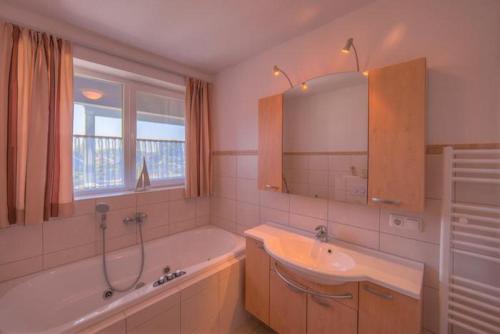 a bathroom with a tub and a sink and a mirror at Mitteldeck 523 in Rechlin