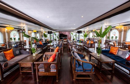 a restaurant with couches and tables and chairs at Indochine Cruise Lan Ha Bay in Ha Long