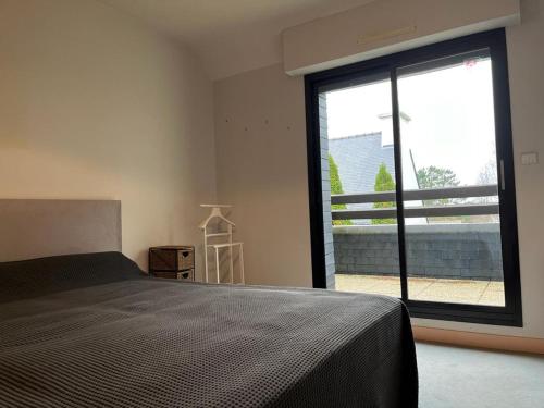 une chambre avec un lit et une grande fenêtre dans l'établissement VILLA TYJOB, à Moëlan-sur-Mer
