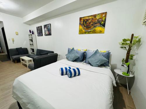 a bedroom with a large white bed with blue pillows at Vinia Infinity Studio 1 Near Malls with WiFi and Netflix in Manila