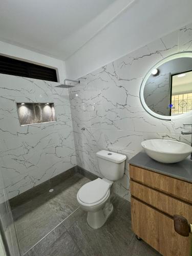 a bathroom with a toilet and a sink at Hotel Maratea Melgar in Melgar