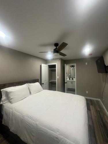 a bedroom with a white bed and a ceiling fan at Apt 6 - High Plains Lodge at Nomad Landing in Clayton