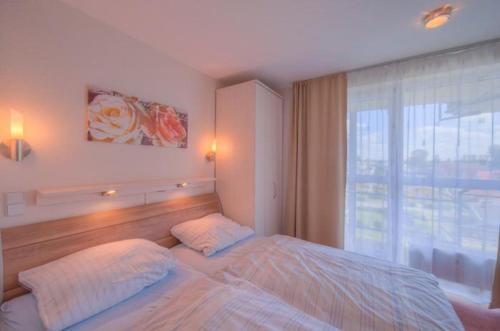 a bedroom with a bed and a large window at Seeadler 205 in Rechlin