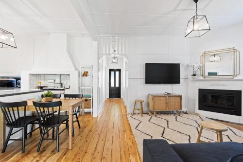 a living room with a table and chairs and a tv at Johnno's Cottage - Prime Location - Sleeps 4 in Orange