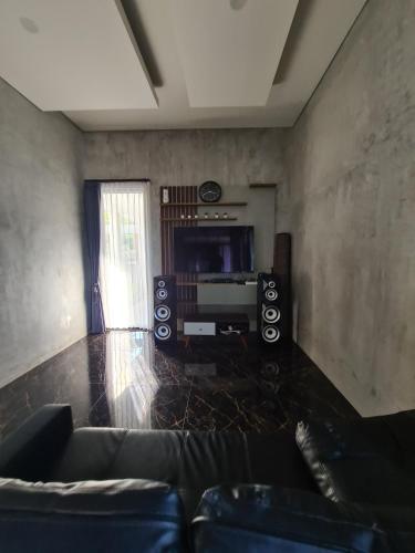 sala de estar con sofá y TV en Villa Dedayu, en Tlekung
