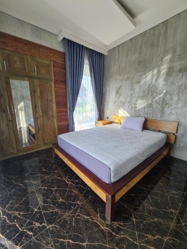 1 dormitorio con 1 cama grande frente a una ventana en Villa Dedayu, en Tlekung