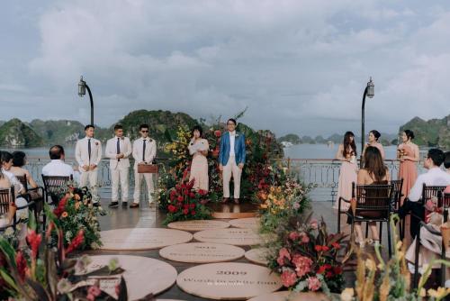 a bride and groom walking down the aisle at their wedding ceremony at Indochine Cruise Lan Ha Bay in Ha Long