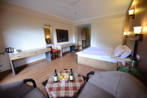 マナリにあるGoroomgo Park Paradise Manali - Elevator Lift & Parking Facilitiesのベッドとテーブルが備わるホテルルームです。