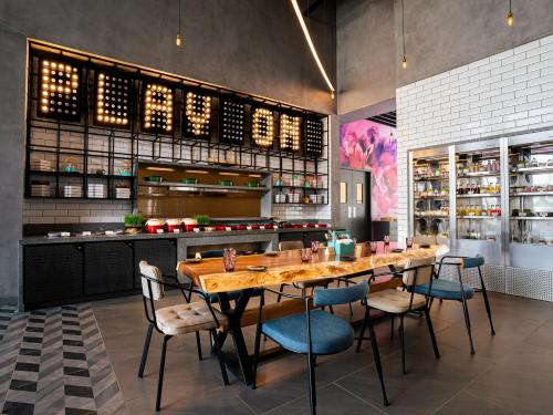 a dining room with a wooden table and chairs at Moxy Bengaluru Airport Prestige Tech Cloud in Devanahalli-Bangalore