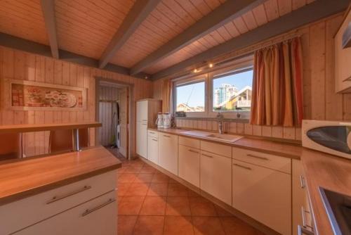a large kitchen with white cabinets and a window at Wildgans Classic 29 in Rechlin