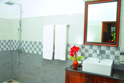 a bathroom with a sink and a mirror at Hannaford House Bentota in Bentota