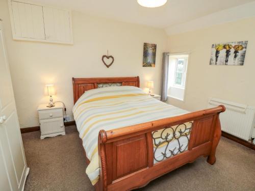 a bedroom with a bed and two lamps and a window at Abbey View Cottage in Hawsker