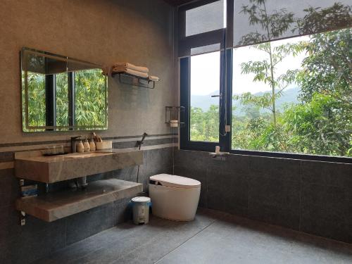 a bathroom with a sink and a toilet and a window at Lake House in Ha Giang