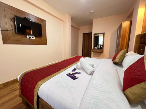 a hotel room with a bed with a tv on the wall at Canadian Cottage Dalhousie in Dalhousie