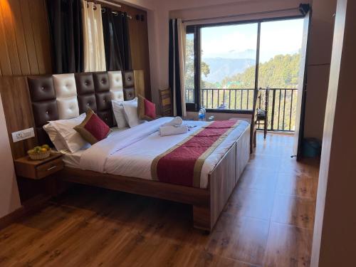 a bedroom with a large bed with a large window at Hotel Canadian forest view in Dalhousie