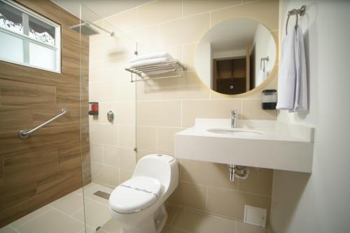 a bathroom with a toilet and a sink and a mirror at Hotel Barranqueros Soledén in Armenia