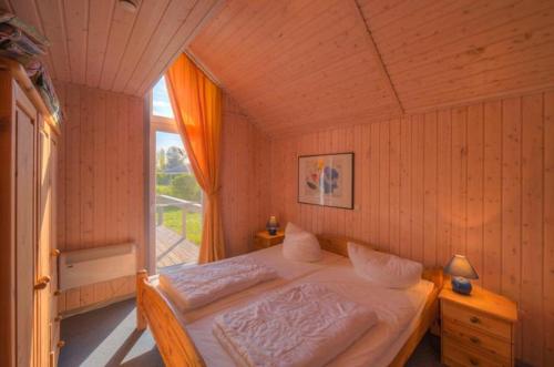 ein Schlafzimmer mit einem Bett in einem Zimmer mit Fenster in der Unterkunft Seeschwalbe Classic 58 in Rechlin