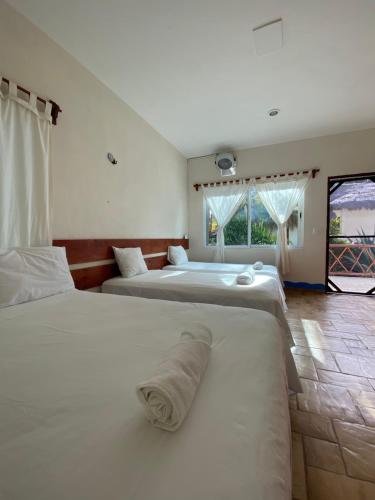two beds in a hotel room with a window at Ikarus kiteboarding in Isla Mujeres