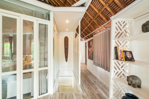 a hallway of a house with white walls and wooden floors at Seminyak Villa Kubuku in Seminyak