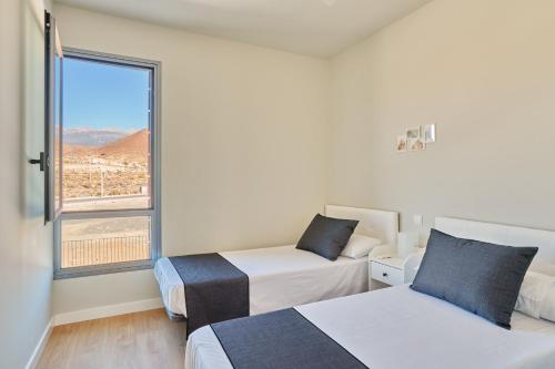 AbadesにあるCielo de Abades Live Canariasのベッドが2つと大きな窓がある部屋