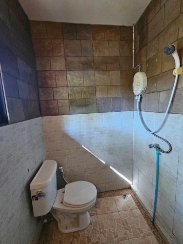 uma casa de banho com um WC e um chuveiro em Fire Fly Chalet em Ban Chom Phon