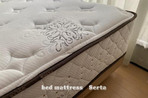 a white bed mattress with a snowflake on it at Hachioji Akatsuki Guest House in Hachioji