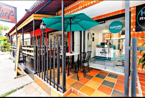 メデジンにあるHotel boutique San Pabloのテーブル、椅子、パラソル付きのレストラン