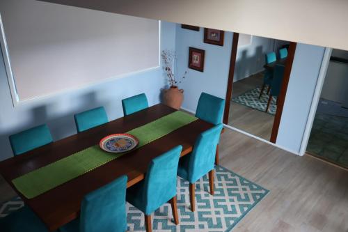 a dining room with a table and blue chairs at Dolphinview in Denhams Beach