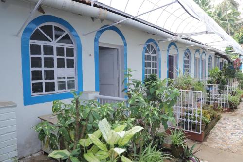 a blue and white house with plants in front of it at Zappia Cove Resort Palolem in Palolem