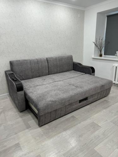 a couch sitting in a living room at Уютные 2х комнатные апартаменты на юбилейной in Uralsk