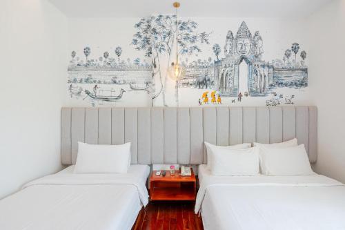 two beds in a room with a wall mural at Victoria Central Residence in Siem Reap