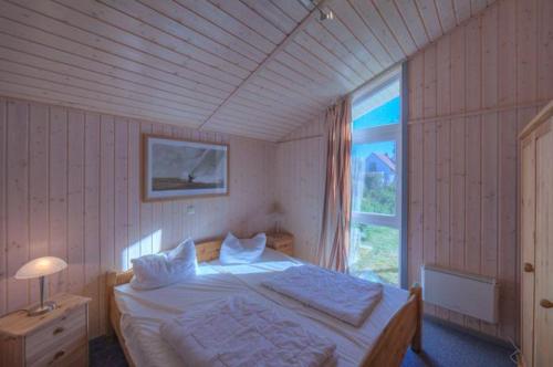a bedroom with a bed and a large window at Seeschwalbe 69A in Rechlin