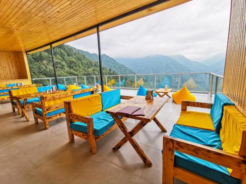 a restaurant with tables and chairs and a view of mountains at Eco House Merisi in Merisi
